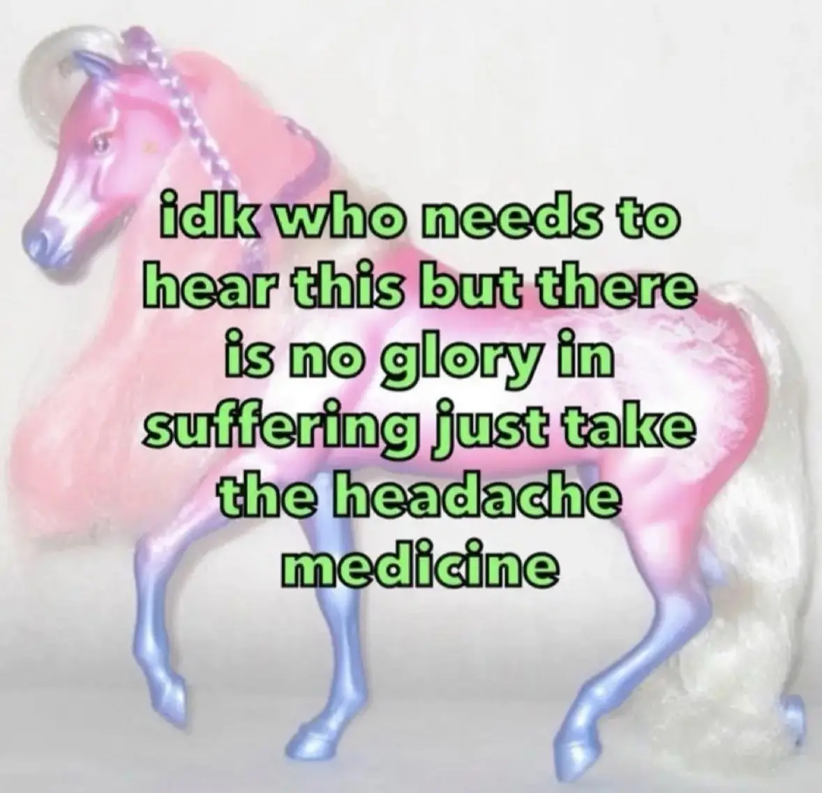 A pink plastic toy horse with a clear plastic horn and purple bridle stands against a plain background. Green text overlaid…