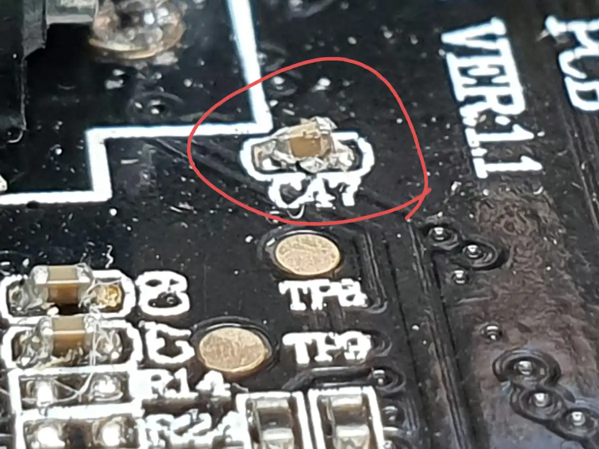 A close-up of a circuit board shows a small electronic component labeled 'CAT' circled in red. The board has other labeled…