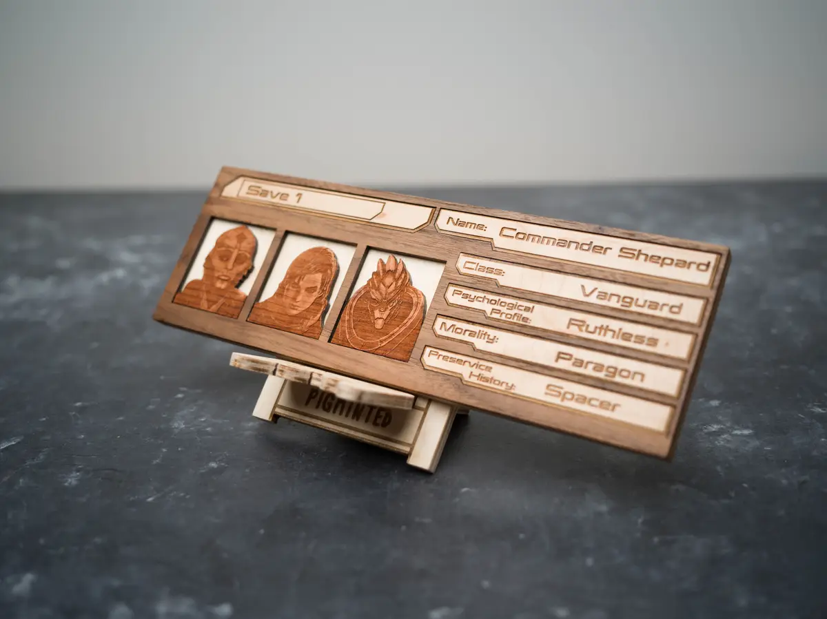 A wooden, laser-etched physical replica of a Mass Effect character save file, labeled 'Save 1', showing Commander Shepard's…