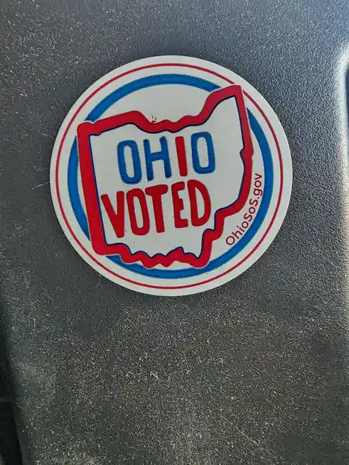 A circular Ohio voter sticker with red and blue borders, featuring the outline of the state of Ohio in red with 'OHIO' in…