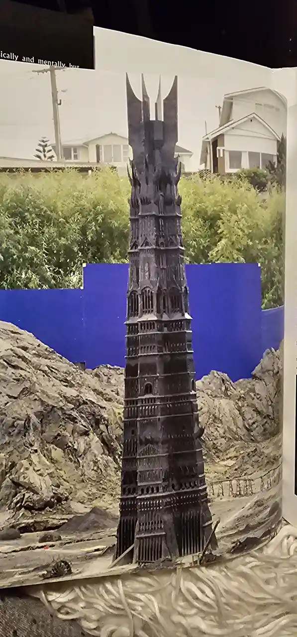 A miniature model of the Dark Lord's tower from 'The Lord of the Rings' is shown in a diorama with rocky terrain and a blue…