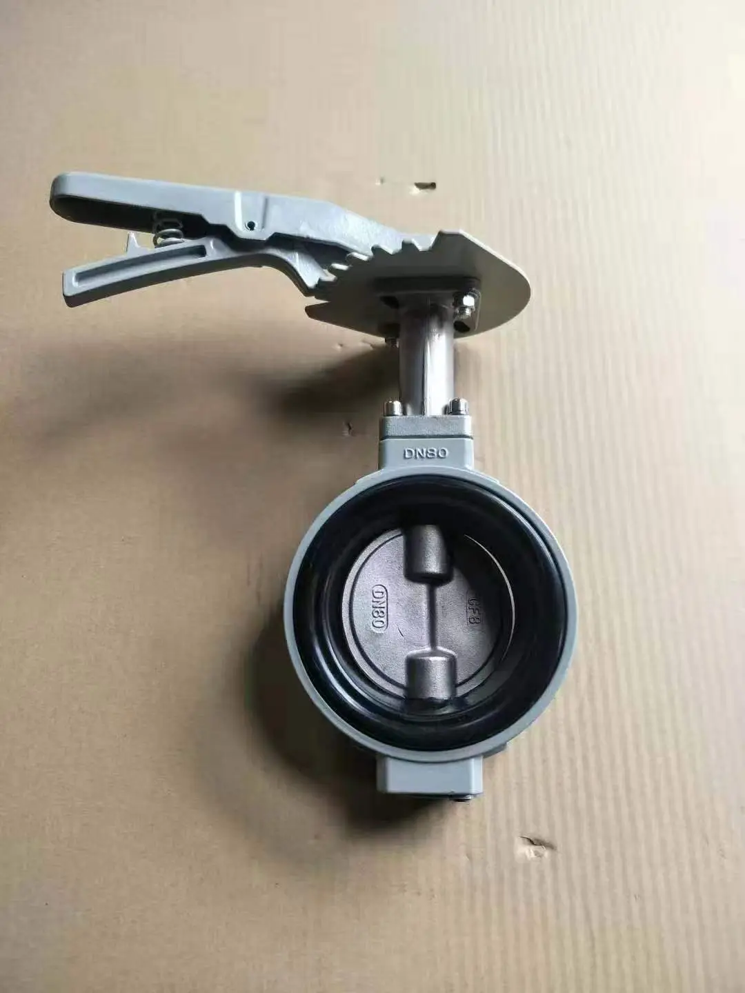 a butterfly valve with a handle shaped like a clothespin is shown on a cardboard surface. The overlaid text reads 'this is a…