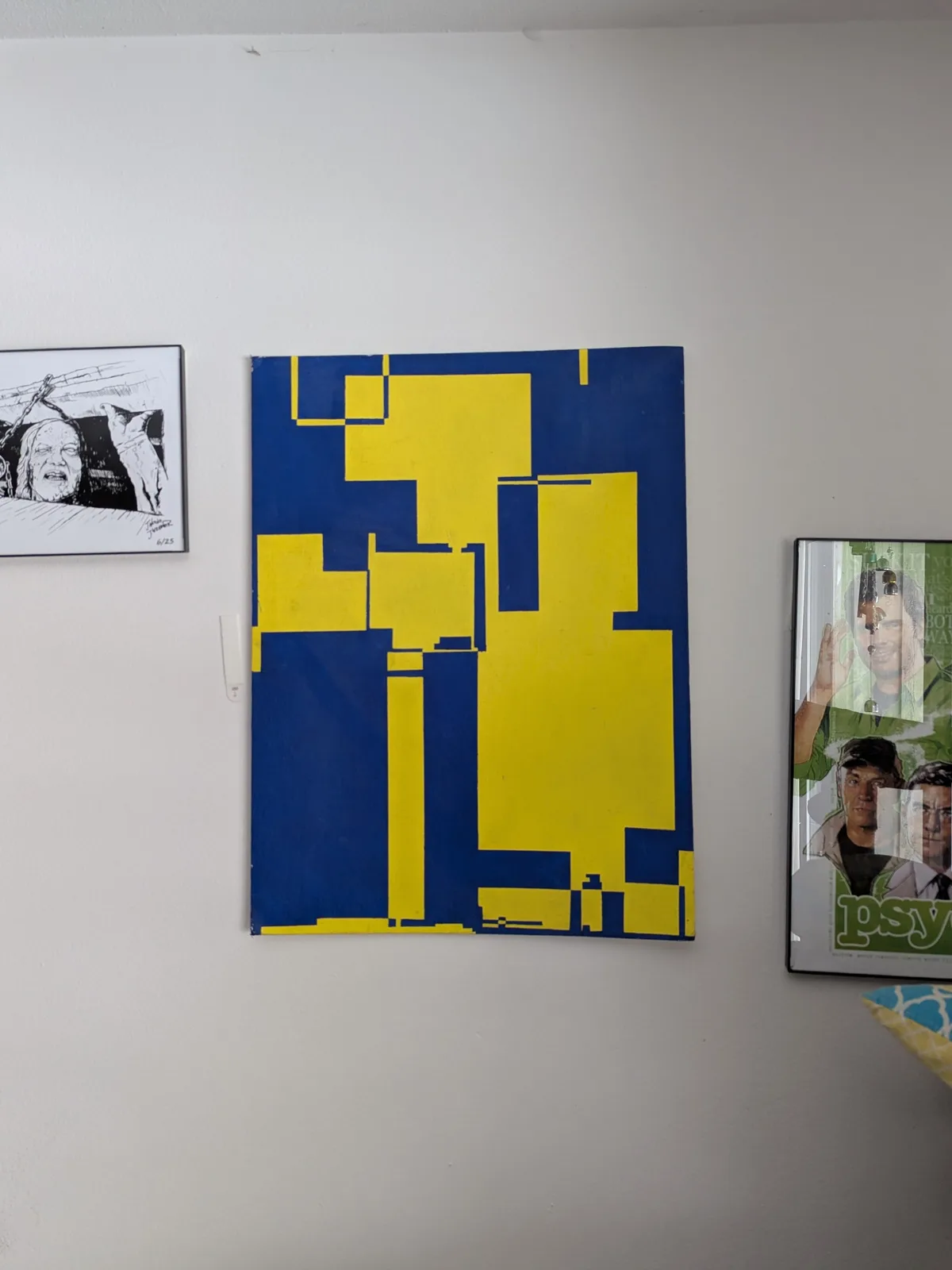 A wall displays three framed artworks: a black-and-white sketch of a screaming face on the left, a large abstract painting…