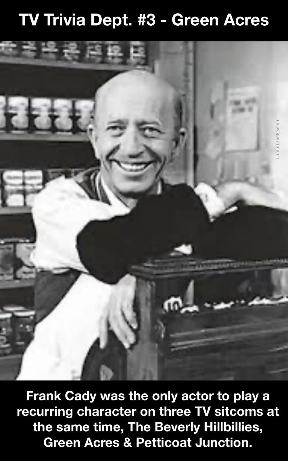 A black-and-white photo shows actor Frank Cady smiling broadly while leaning on a wooden counter in what appears to be a…
