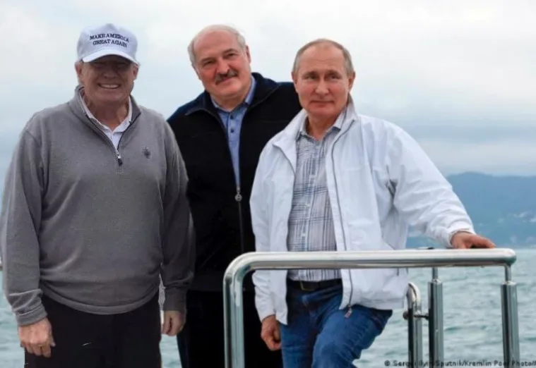 Three men stand on a boat with water and hills in the background. The man on the left wears a white cap with the text 'MAKE…