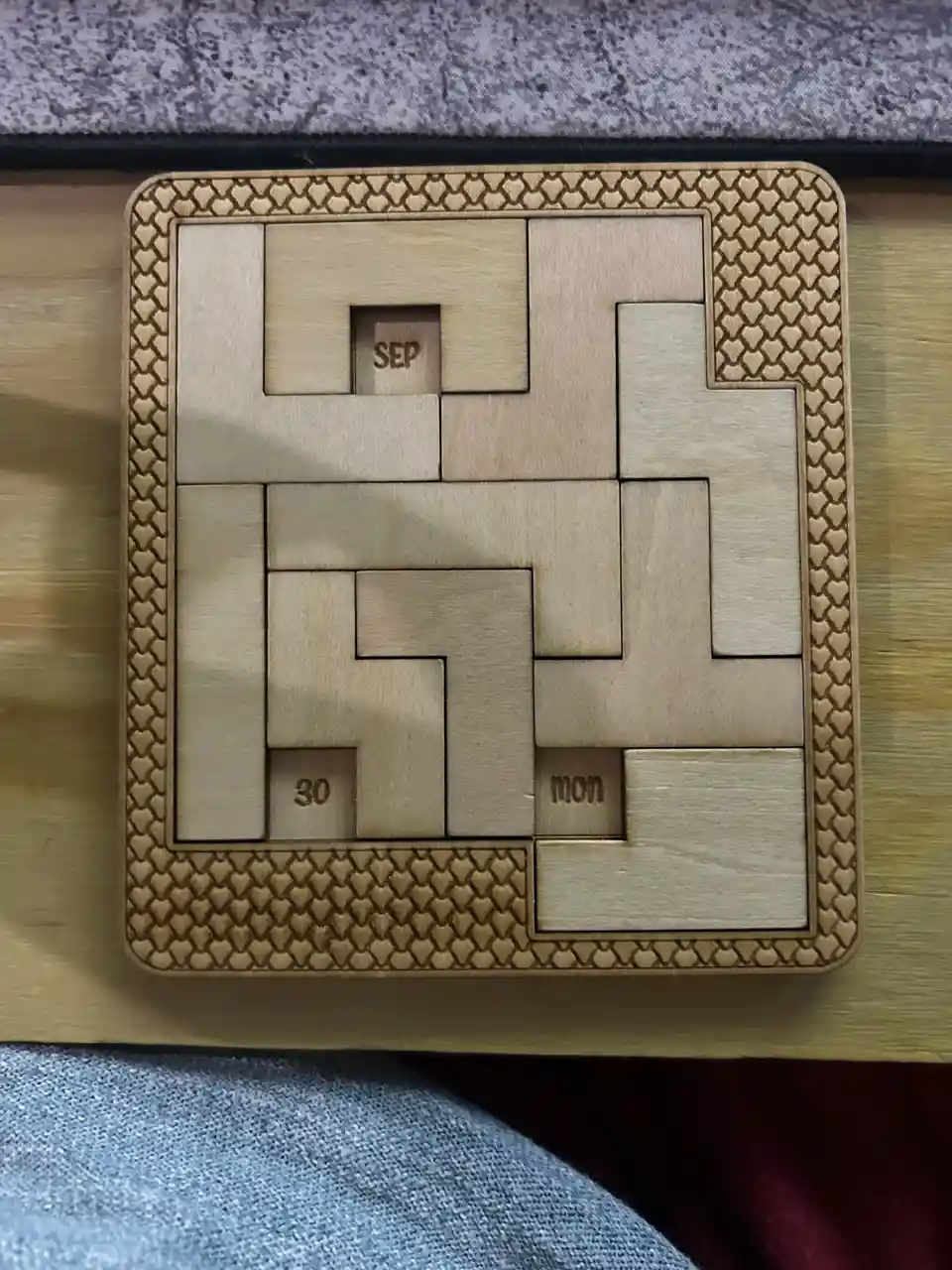 A wooden puzzle calendar with interlocking pieces forming a grid, showing 'SEP' in the top center, '30' in the bottom left…