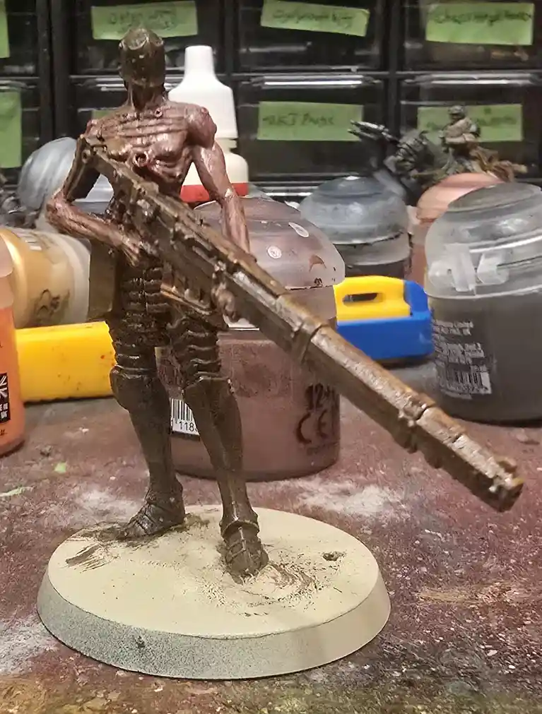 A heavily weathered and unpainted miniature soldier figurine, appearing as if made of clay or raw metal, stands on a…