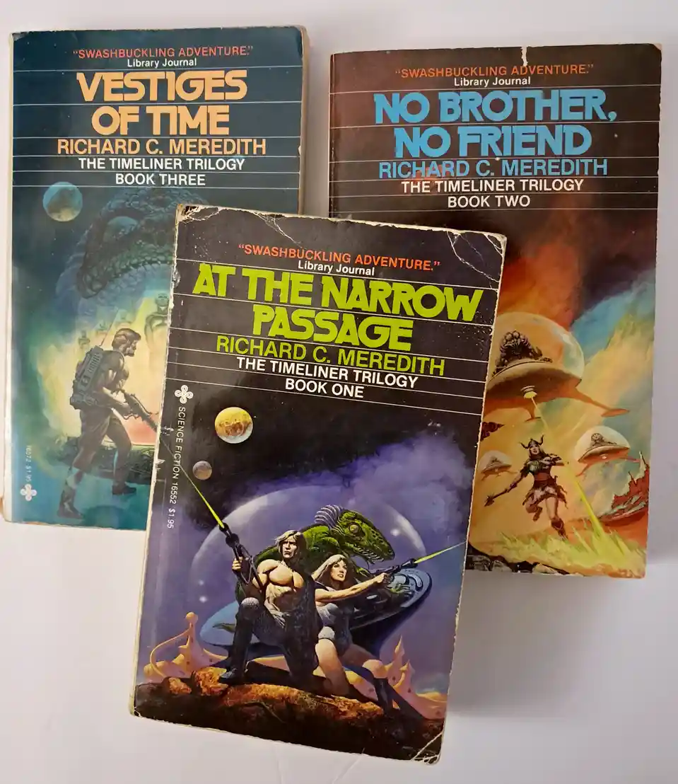 Three vintage science fiction paperback books by Richard C. Meredith, part of 'The Timeliner Trilogy,' are arranged on a…