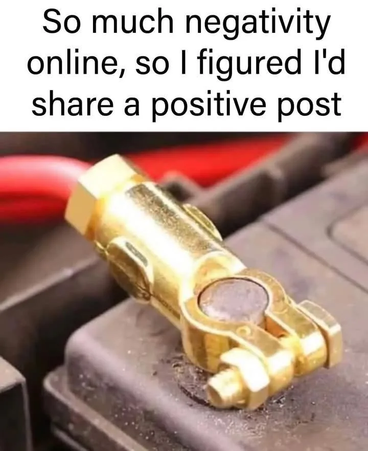 A close-up photo shows a gold-colored, hexagonal battery terminal clamp attached to a dark, dusty car battery. A red cable…