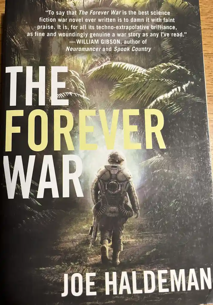 The image shows the cover of Joe Haldeman's science fiction novel 'The Forever War'. A soldier in futuristic armor walks…