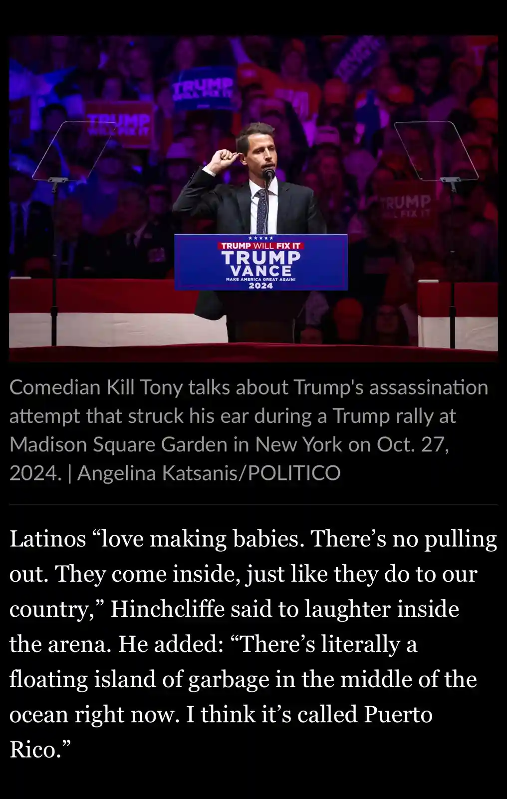 A man in a suit stands at a podium labeled 'TRUMP VANCE 2024' with 'TRUMP WILL FIX IT' above it, touching his ear as if…
