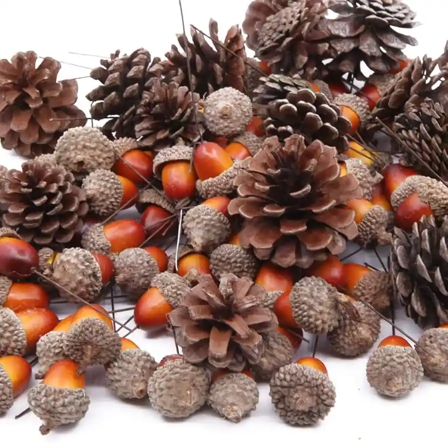 A pile of brown pinecones and orange acorns on thin wire stems against a white background, with no visible text or overlay.