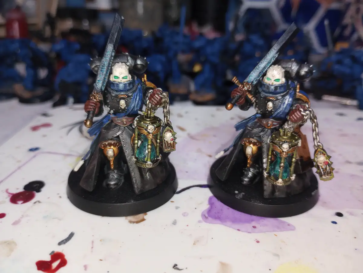 Two nearly identical painted miniature figurines of grim-faced, armored warriors with green glowing eyes, holding swords and…