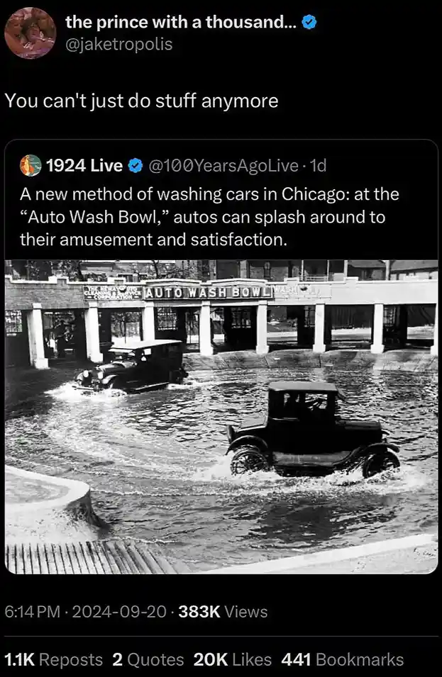 A black-and-white photo shows two vintage cars driving through a large, shallow pool of water labeled 'AUTO WASH BOWL' under…