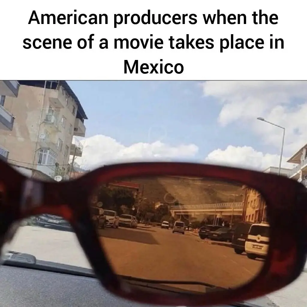 A close-up photo of a pair of dark red sunglasses viewed from inside a car, with the reflection in the lenses showing a…