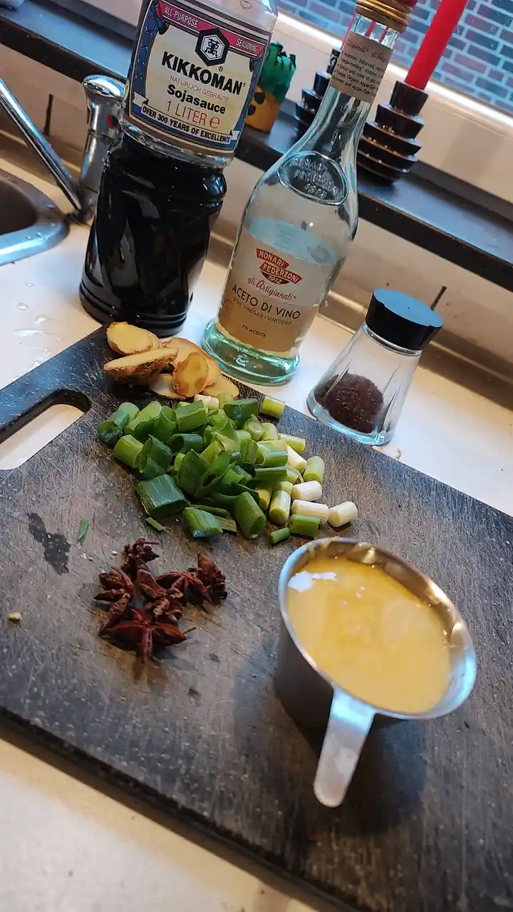 A kitchen counter shows a large bottle of Kikkoman soy sauce, a bottle of Monari Federzoni wine vinegar, a small spice…