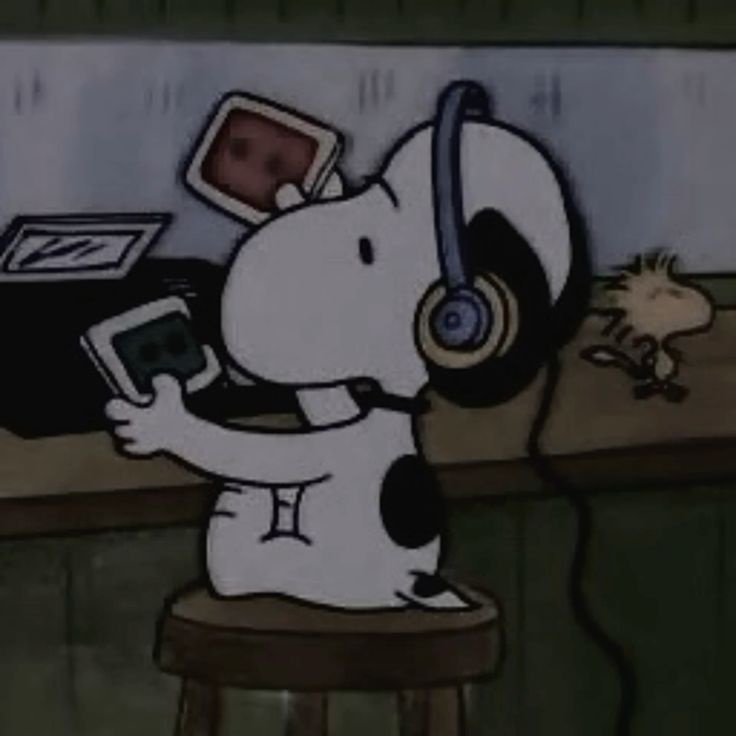 A cartoon dog, Snoopy, sits on a stool wearing headphones and holding a cassette player, looking focused. In the background…