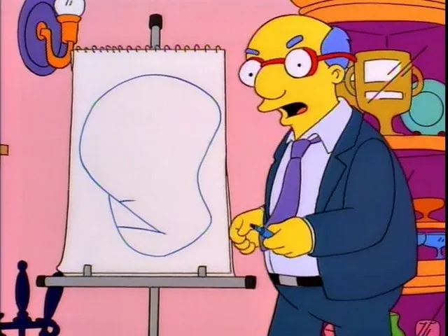 a balding man in a suit and glasses stands beside an easel with a blank sketchpad showing a crude outline of a face with…