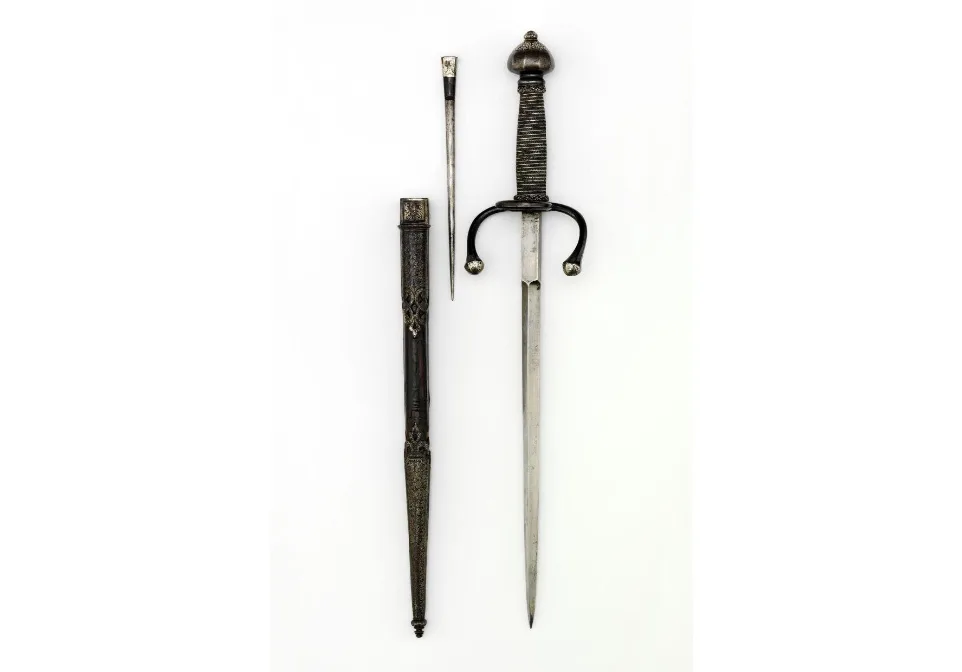 a historical dagger with a decorative hilt and a sheath is displayed against a plain white background. The dagger has a…