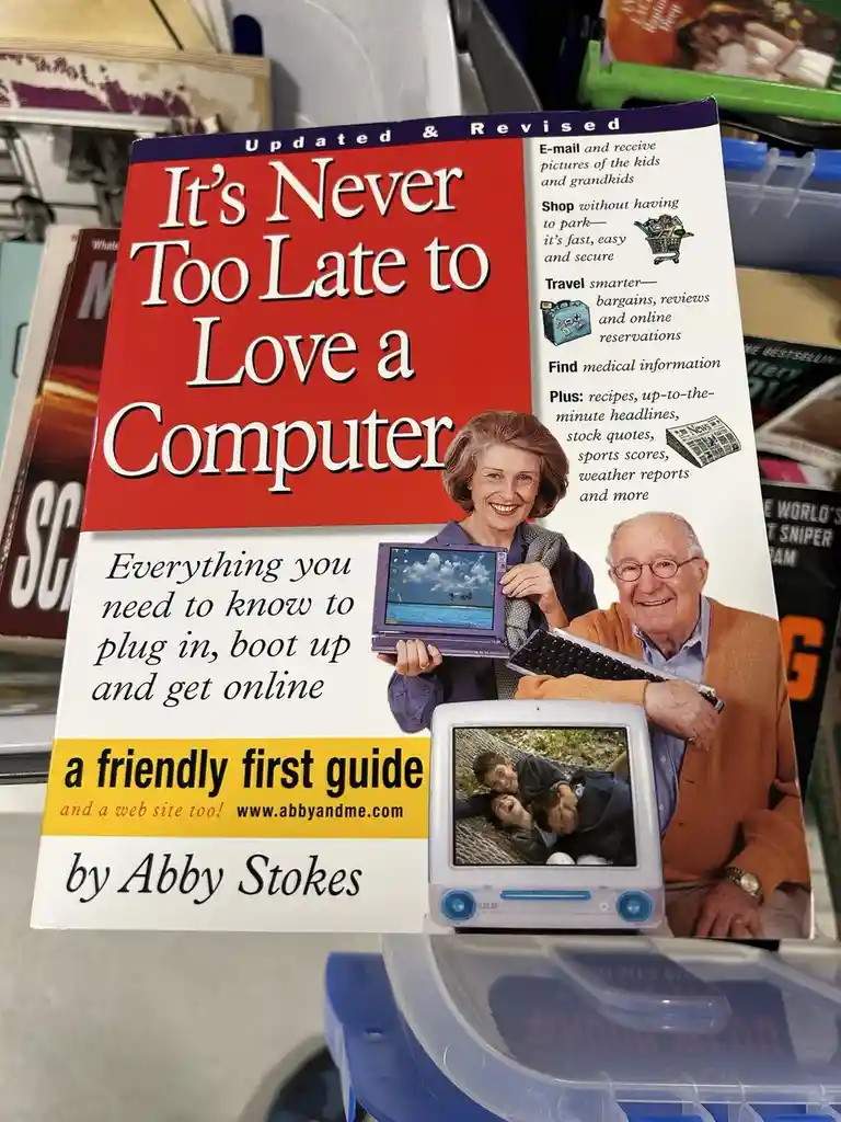 A book cover titled 'It's Never Too Late to Love a Computer' by Abby Stokes, featuring a smiling elderly couple holding a…