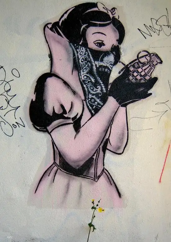 A graffiti-style mural depicts Snow White with dark hair, wearing a pink dress and black gloves, holding a grenade in her…