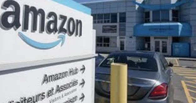 A photo of an amazon sign outside a building with a car parked nearby. The sign reads 'amazon', 'amazon hub', 'visiteurs et…