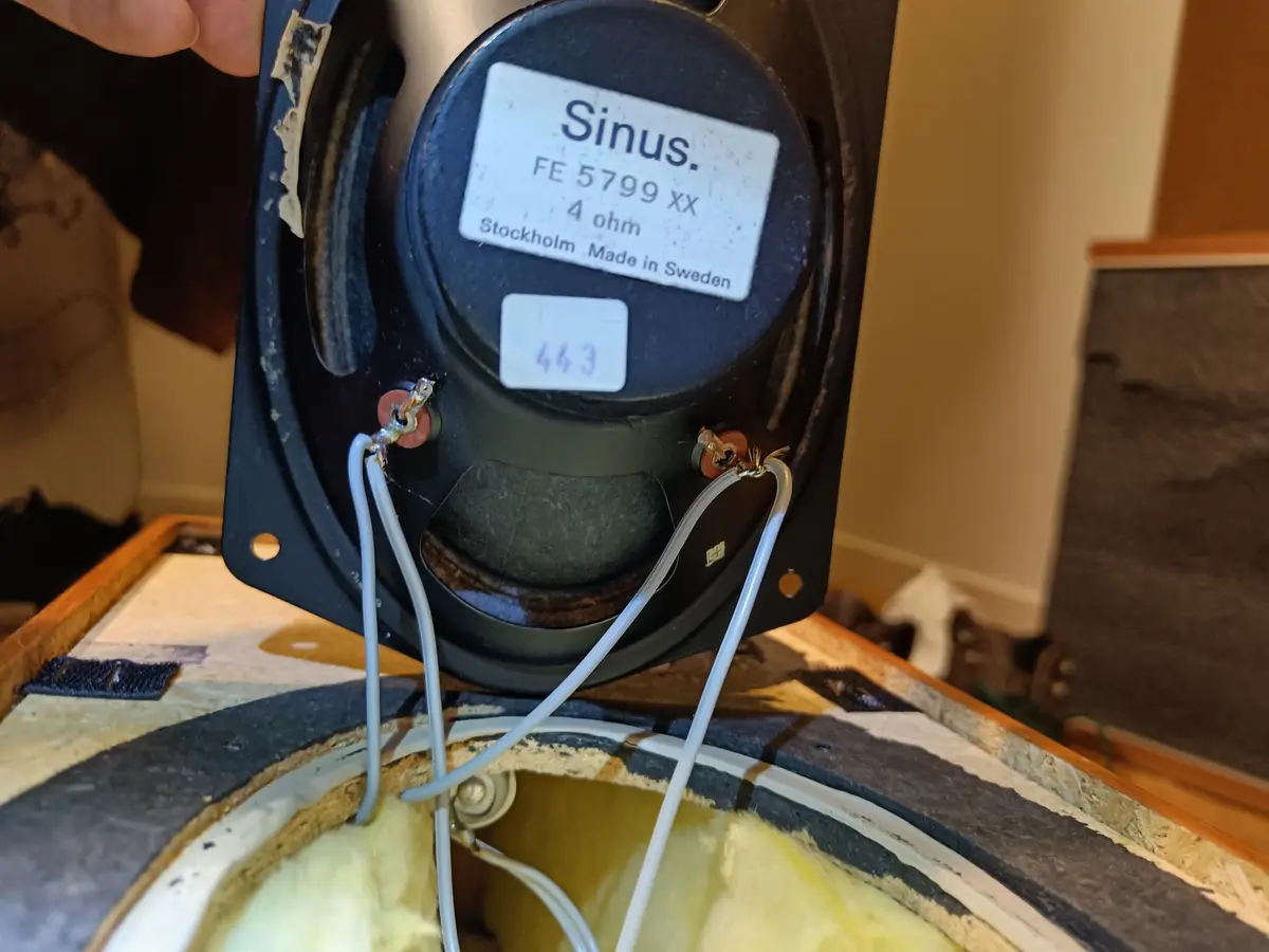 A close-up photo shows the back of a black speaker labeled 'Sinus. FE 5799 XX 4 ohm Stockholm. Made in Sweden' with a small…