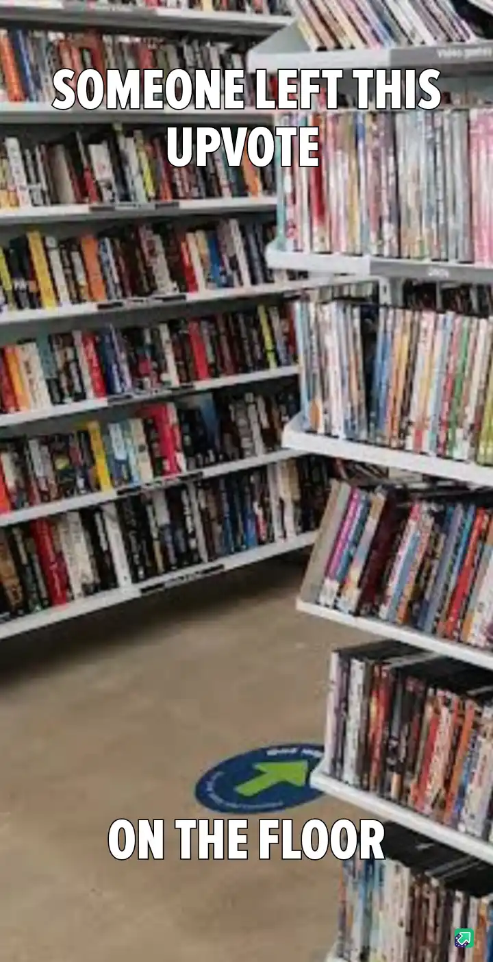 A photo of a bookstore or media store aisle with shelves full of books or DVDs. On the floor, there is a circular blue…