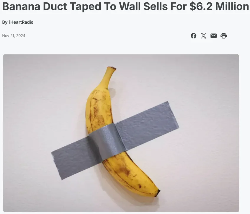 A single yellow banana with brown spots is taped to a plain white wall with two strips of gray duct tape forming an X. The…