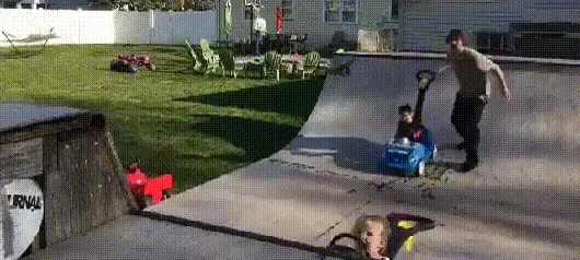 A man in a backyard skatepark pushes two toddlers in separate toy cars down a ramp. In the final frame, the man is shown…