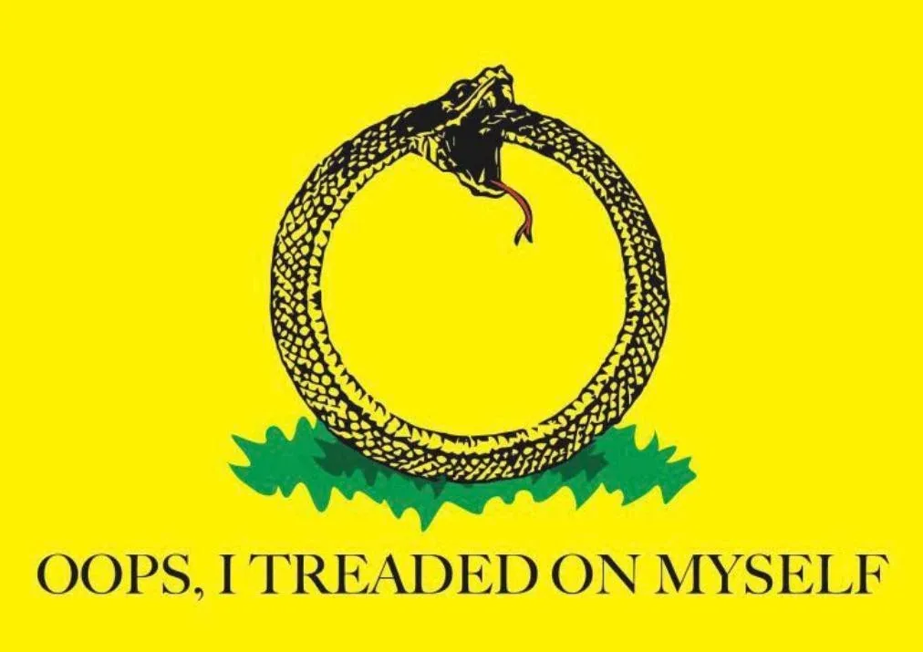The image displays the Gadsden flag, featuring a coiled black rattlesnake on a yellow background with green grass at the…