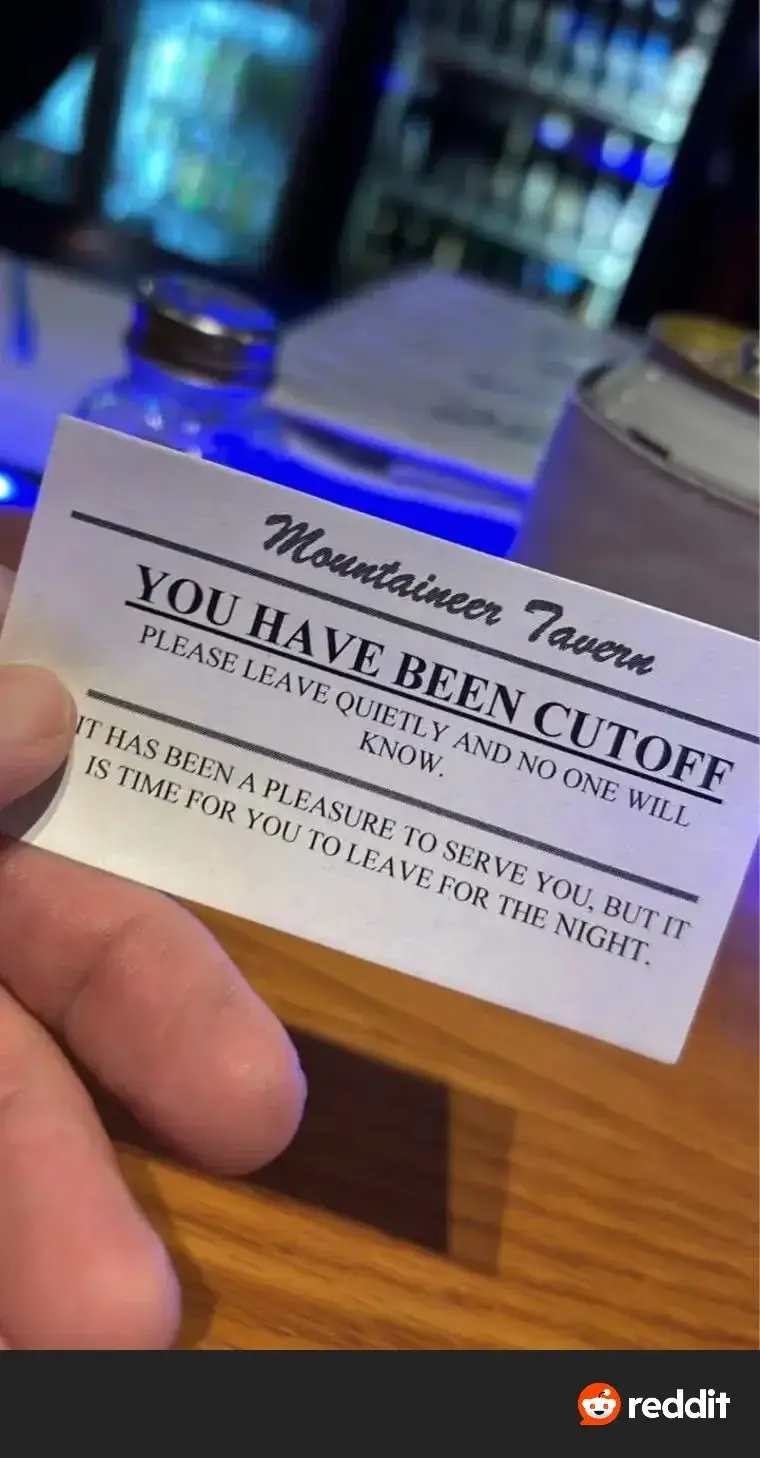 A hand holds a white card from 'Mountaineer Tavern' with bold text stating 'YOU HAVE BEEN CUTOFF' and a polite message…