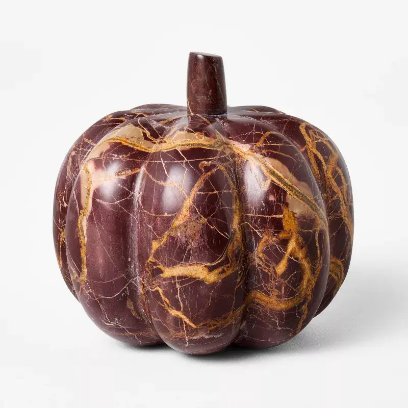 a polished, deep purple marble pumpkin with golden veining and a short stem, photographed against a plain white background…