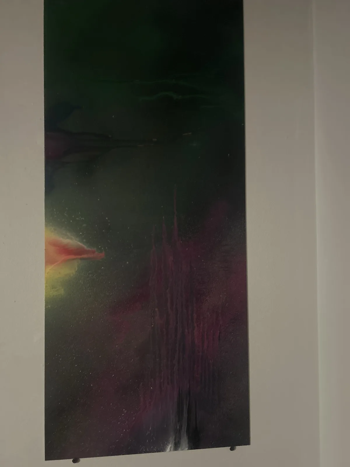 A vertically oriented abstract painting with dark green, purple, and hints of yellow and red swirling colors, mounted on a…