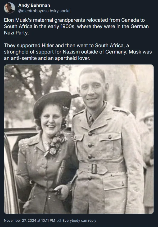 A black-and-white photo shows a smiling man in a military uniform standing beside a smiling woman in a hat and coat…