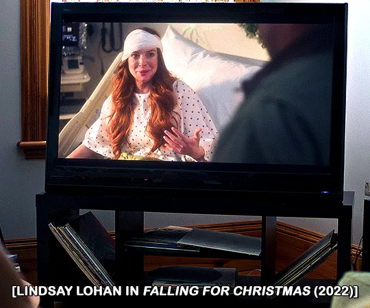 Six identical panels show a scene from the 2022 movie 'Falling for Christmas,' featuring Lindsay Lohan in a hospital bed…