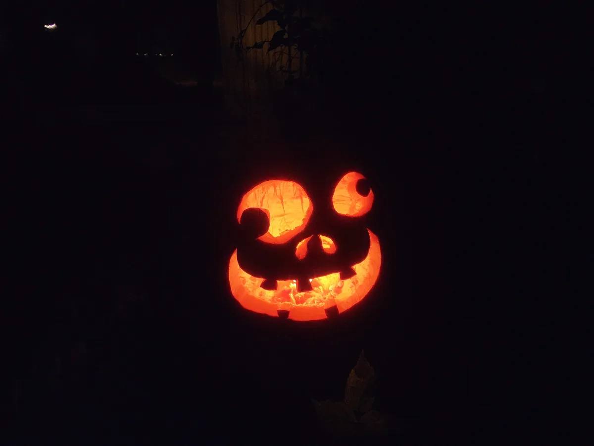 A carved pumpkin with glowing orange light inside, set against a dark night background, has text overlaid that reads 'i'm…
