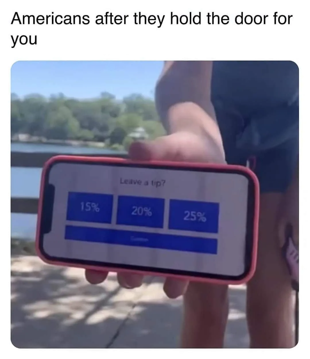 A person holds up a smartphone displaying a tip screen with options for 15%, 20%, and 25%. The overlaid text reads…