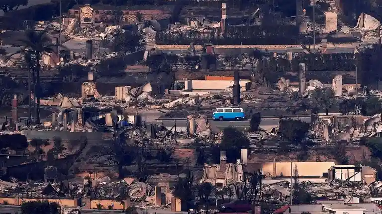 an aerial view shows a blue and white van driving down a road through a neighborhood completely destroyed by fire, with…