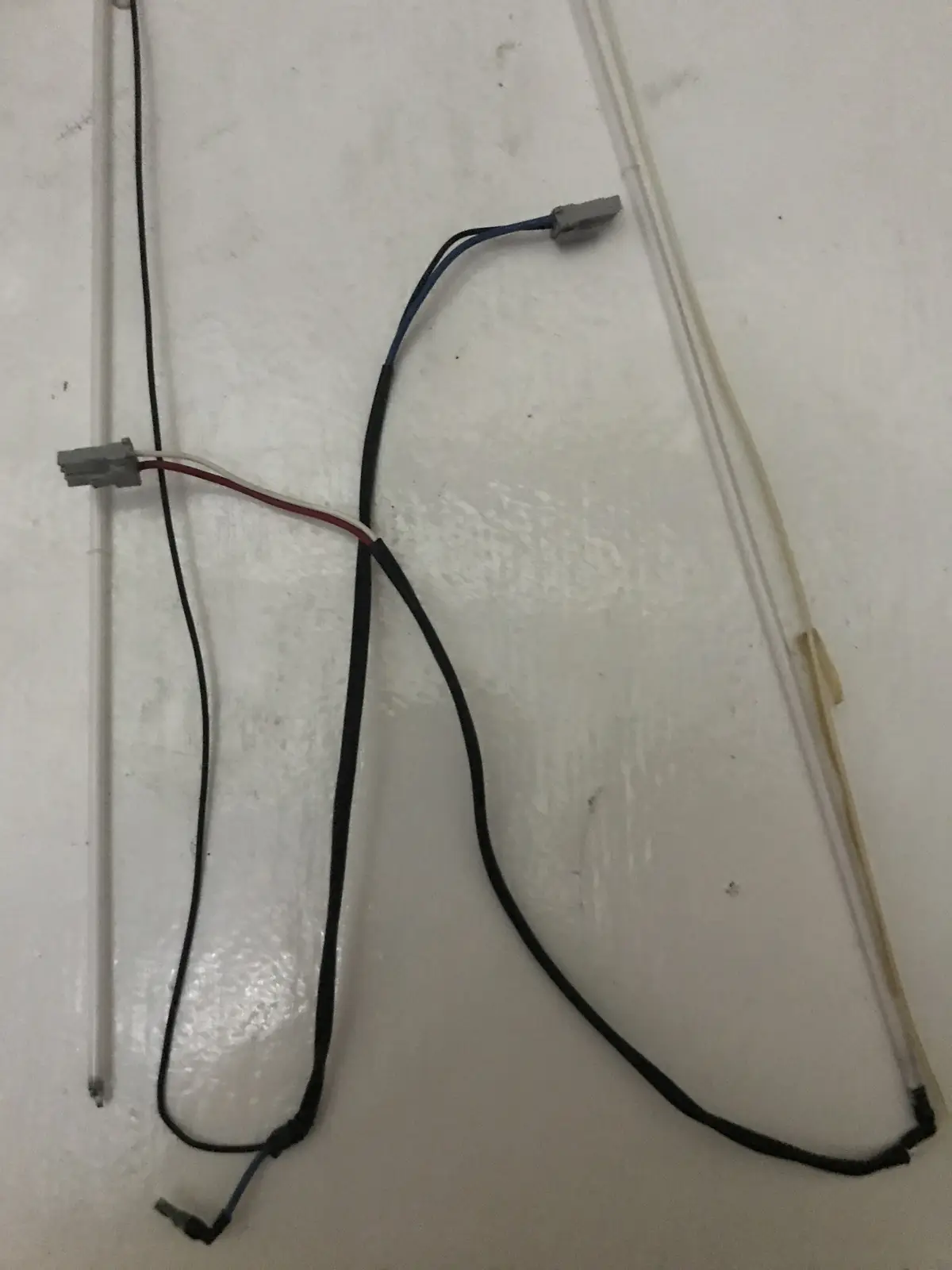 A close-up photo shows two clear plastic tubes with wires attached, resembling glasses or a pair of spectacles. The wires…