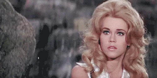The image shows a woman with blonde hair and a white top, appearing shocked or stunned, in a sequence of three frames across…