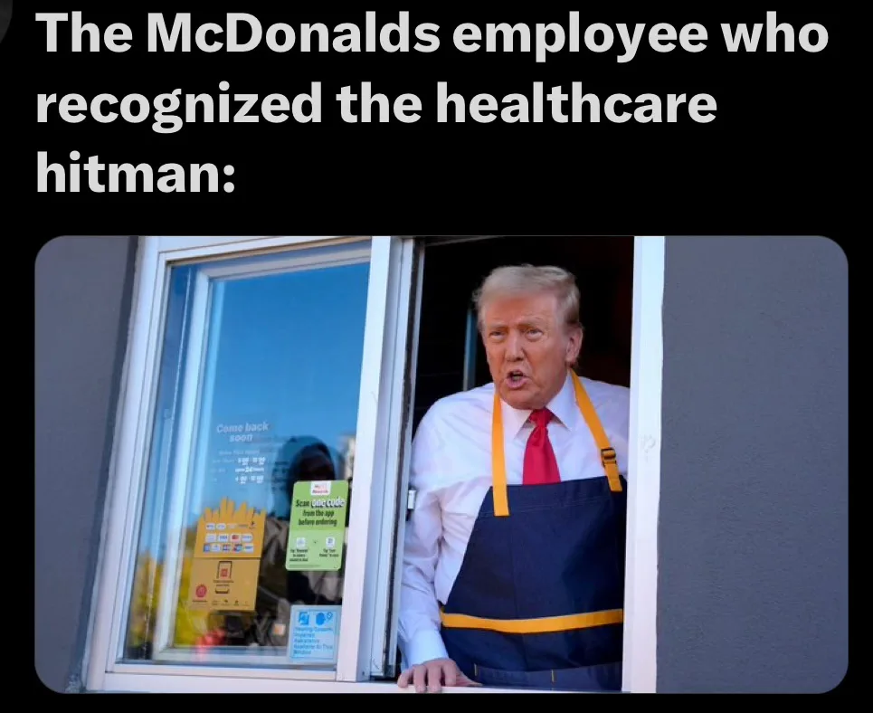 A man with blond hair, wearing a white shirt, red tie, and blue apron with yellow straps, leans out of a McDonald's…