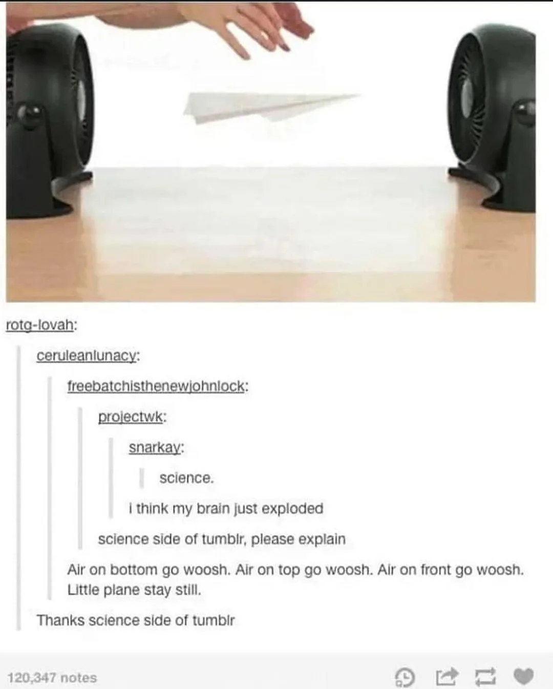 Two black desk fans face each other on a wooden table, blowing air at a paper airplane hovering between them. The image is…