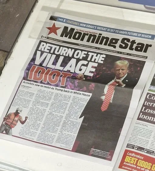 A newspaper titled 'Morning Star' displays a front page with a large headline reading 'RETURN OF THE VILLAGE IDIOT' over a…