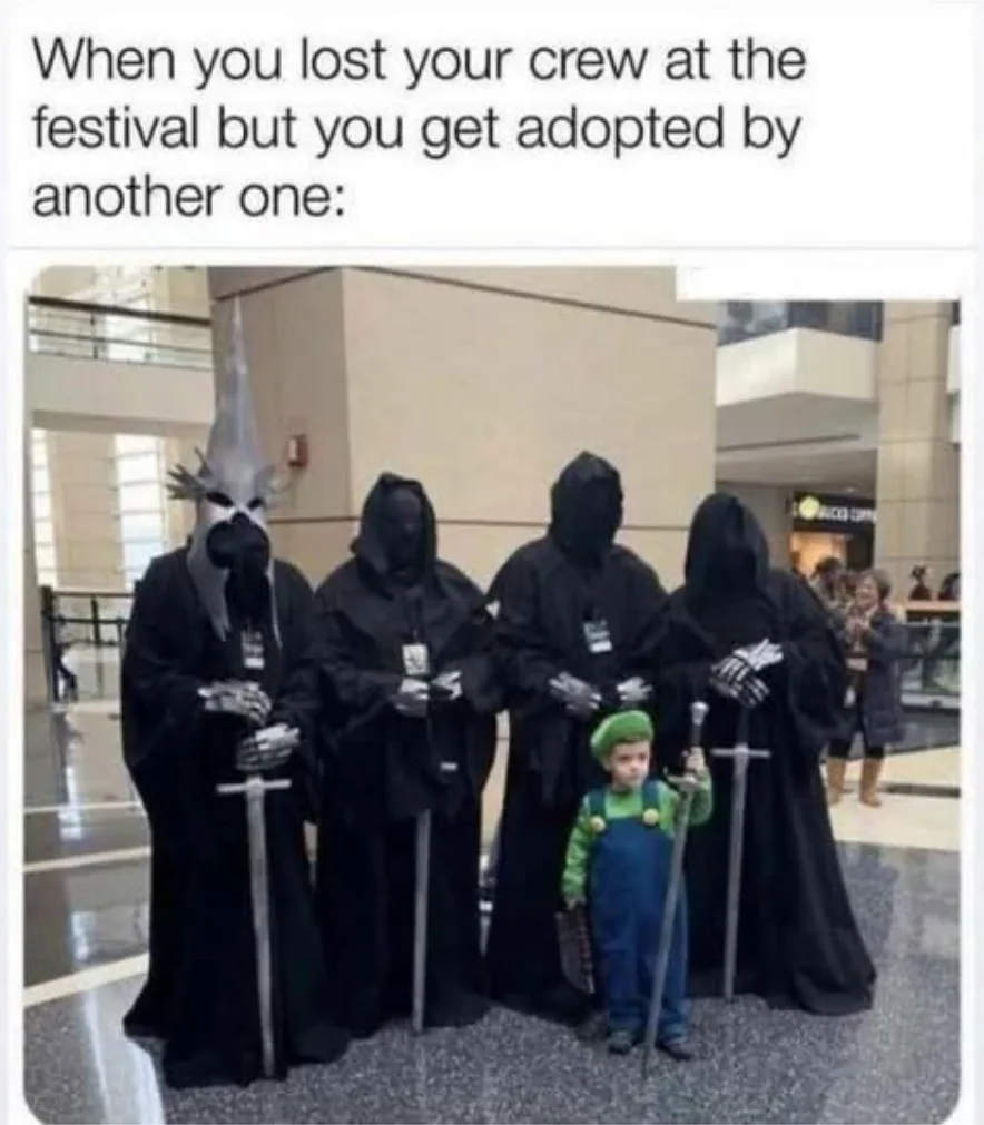 A small child dressed as Luigi stands in front of four tall figures in black hooded robes holding swords, resembling the…