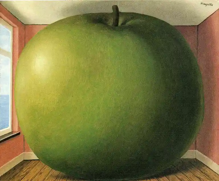 A giant green apple dominates a small room with pink walls and wooden floor, blocking the view of a window. The artist's…