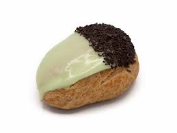 a close-up of a small, golden-brown pastry, likely a croissant or similar, split in half with one side covered in smooth…
