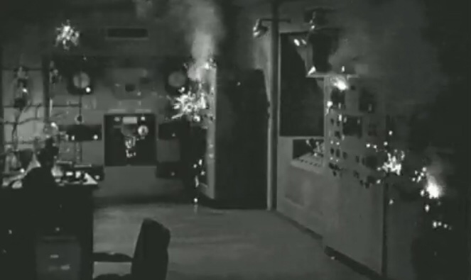 A grainy black-and-white image shows a chaotic, smoke-filled laboratory with sparks flying from equipment and a person…