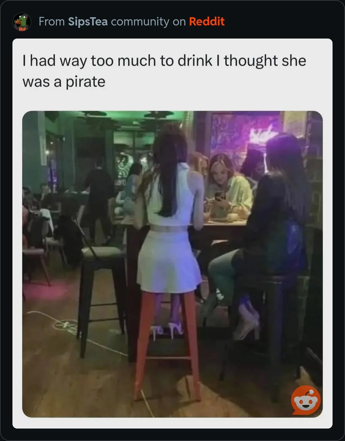 A person with long dark hair, seen from behind, is sitting on a tall red stool at a bar. They are wearing a white outfit and…