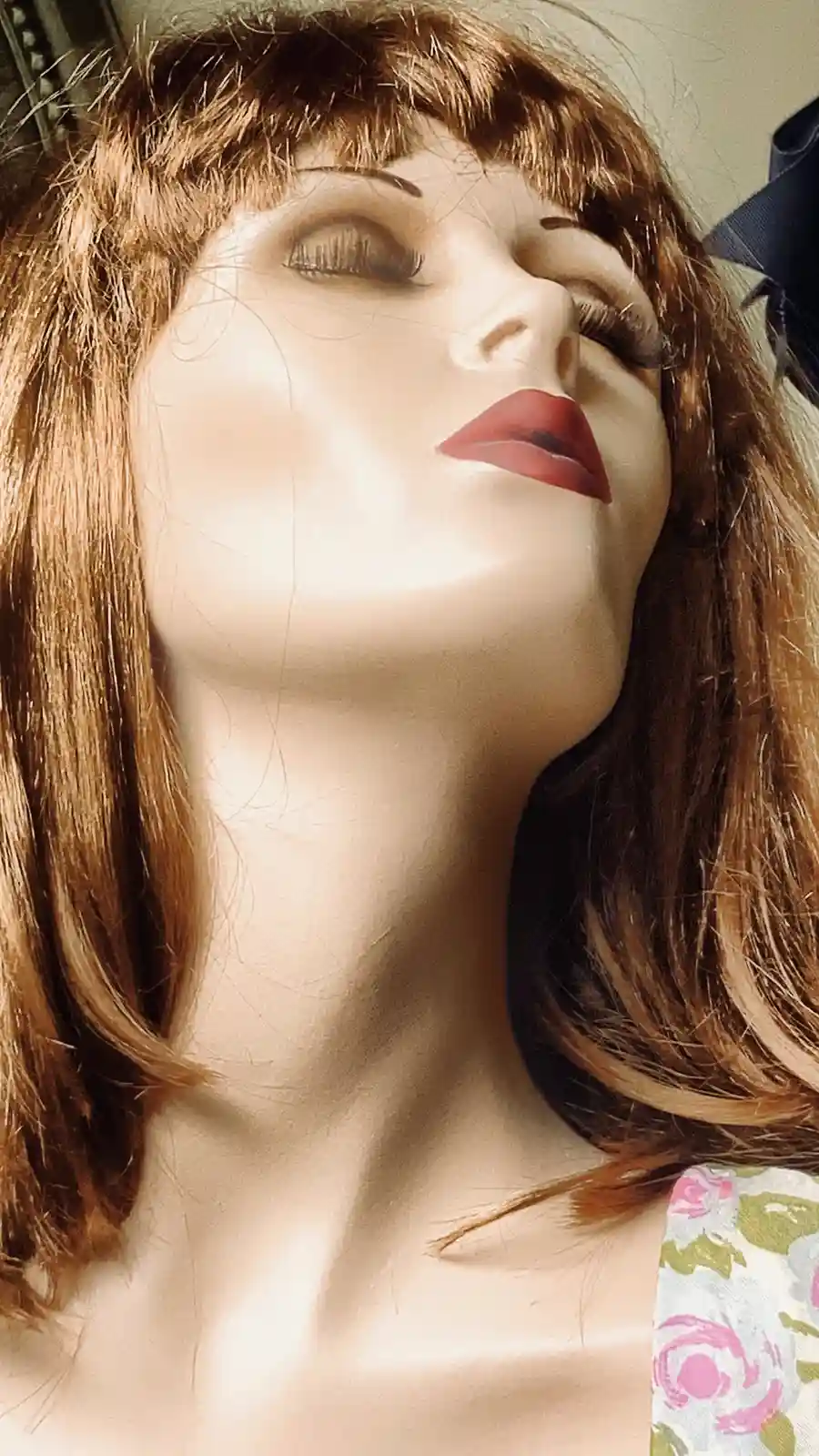 A close-up of a female mannequin with brown hair, red lipstick, and closed eyes tilted upward, overlaid with the text 'i'm…